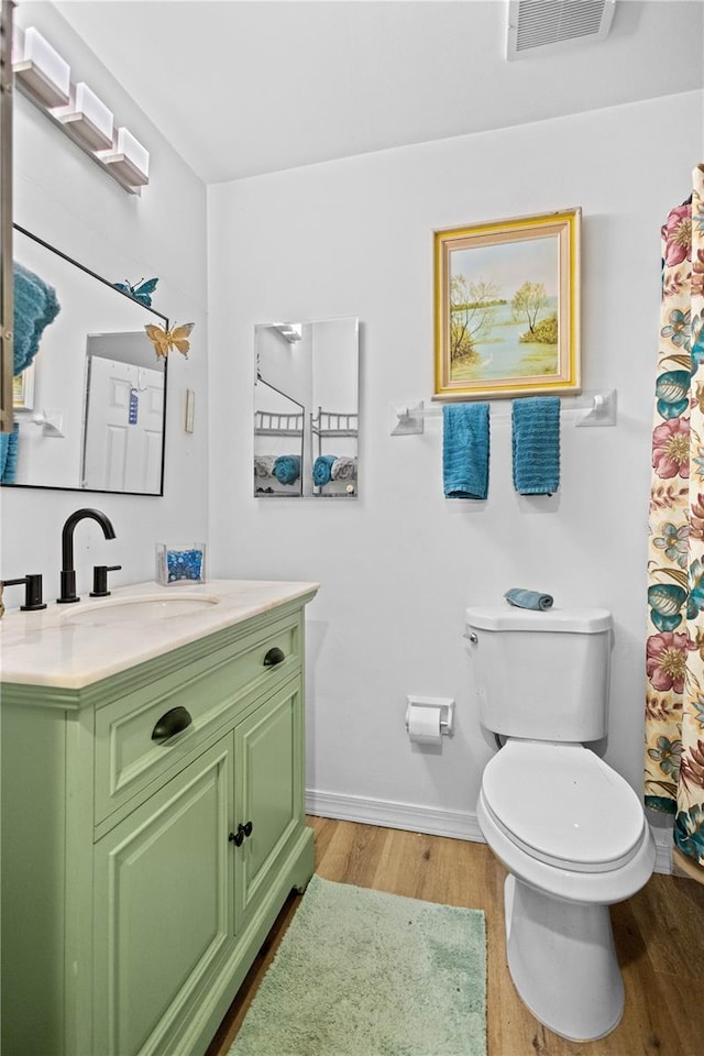 bathroom featuring vanity, hardwood / wood-style flooring, and toilet