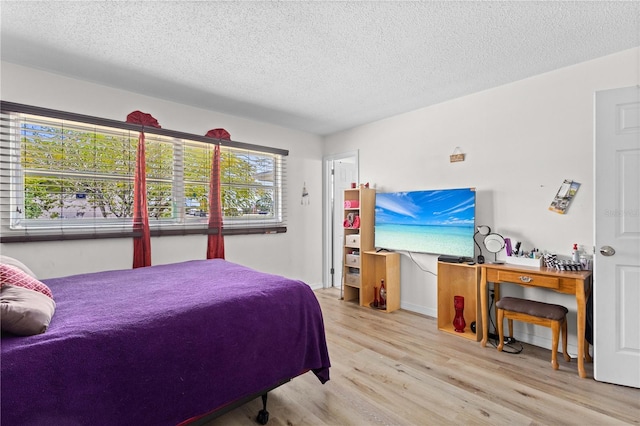 bedroom with a textured ceiling and light hardwood / wood-style flooring