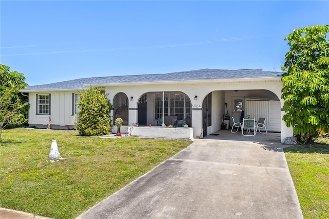 view of front of property featuring a shingled roof, a front lawn, and concrete driveway