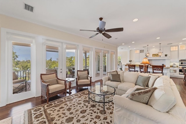 living room featuring dark hardwood / wood-style floors, ornamental molding, ceiling fan, and french doors