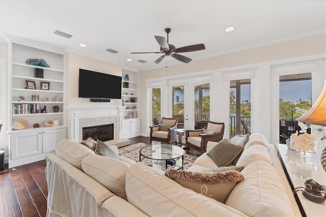 living room with a premium fireplace, crown molding, ceiling fan, and dark hardwood / wood-style flooring