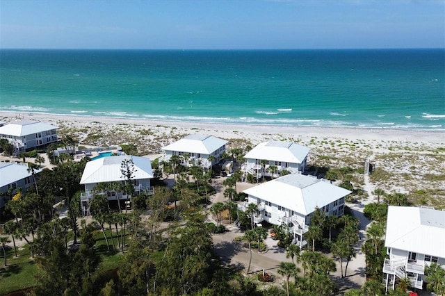 birds eye view of property with a water view and a beach view