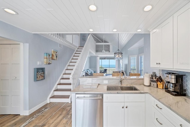 kitchen featuring sink, kitchen peninsula, white cabinetry, and stainless steel dishwasher