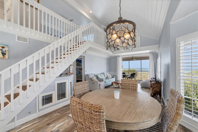 dining area with dark hardwood / wood-style flooring, a high ceiling, and an inviting chandelier