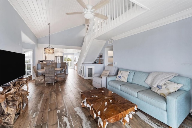 living room with ceiling fan with notable chandelier, high vaulted ceiling, dark wood-type flooring, and crown molding