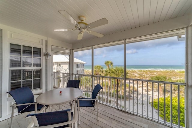 sunroom / solarium featuring a water view and ceiling fan