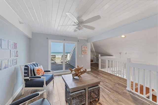 living room featuring light hardwood / wood-style flooring, a water view, ceiling fan, and wood ceiling