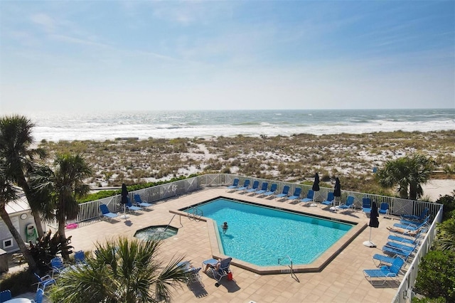 view of swimming pool featuring a water view and a patio