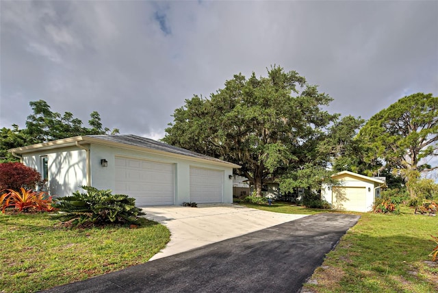 exterior space with a garage, an outdoor structure, and a lawn