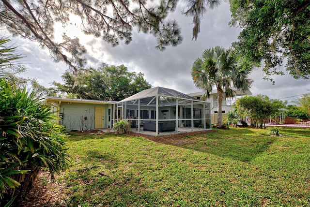 back of property featuring a lawn and glass enclosure