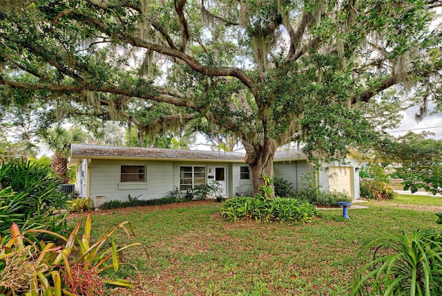 ranch-style house featuring a garage and a front lawn