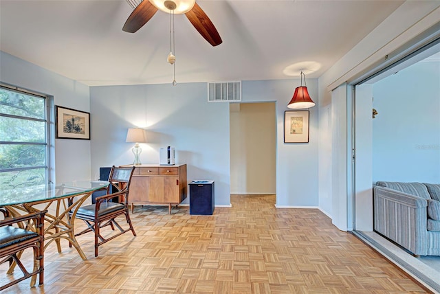 dining space featuring ceiling fan and light parquet flooring