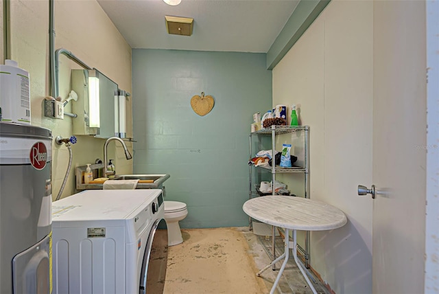 bathroom with sink, electric water heater, washer / clothes dryer, concrete flooring, and toilet