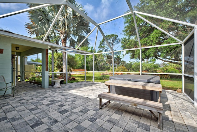 view of patio with glass enclosure and a covered hot tub