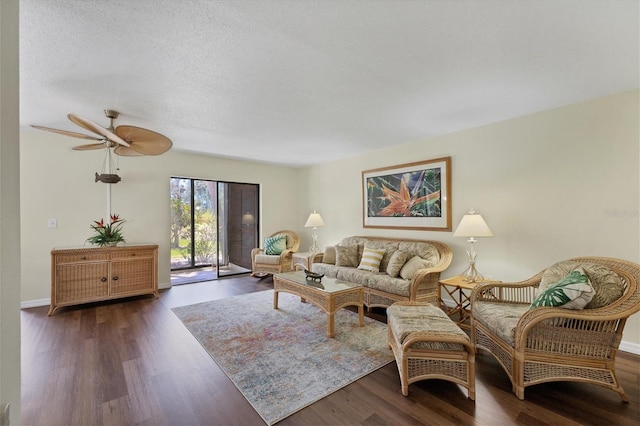 living room featuring a textured ceiling, ceiling fan, and dark wood-type flooring