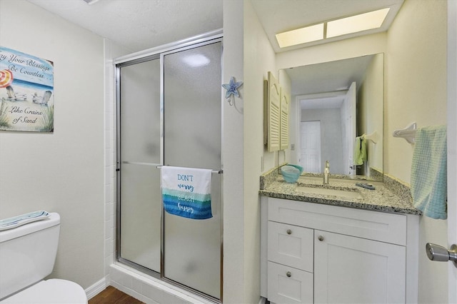 bathroom with walk in shower, toilet, vanity, and hardwood / wood-style floors