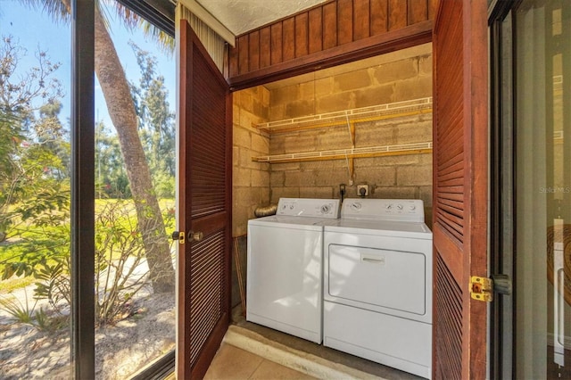 washroom with washer and clothes dryer, hookup for an electric dryer, and light tile floors