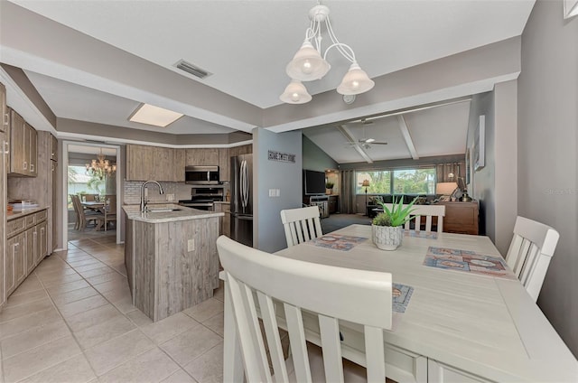 tiled dining room with ceiling fan with notable chandelier, sink, and lofted ceiling with beams