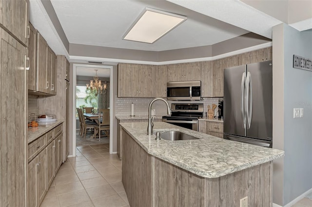 kitchen featuring a chandelier, tasteful backsplash, stainless steel appliances, sink, and light tile flooring