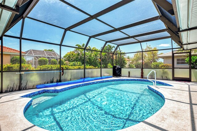 view of swimming pool with a lanai and a patio area