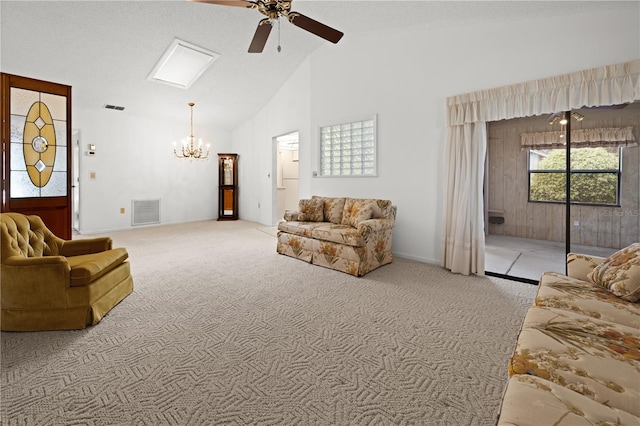 carpeted living room with high vaulted ceiling and ceiling fan with notable chandelier