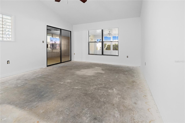 spare room with ceiling fan, lofted ceiling, and concrete floors