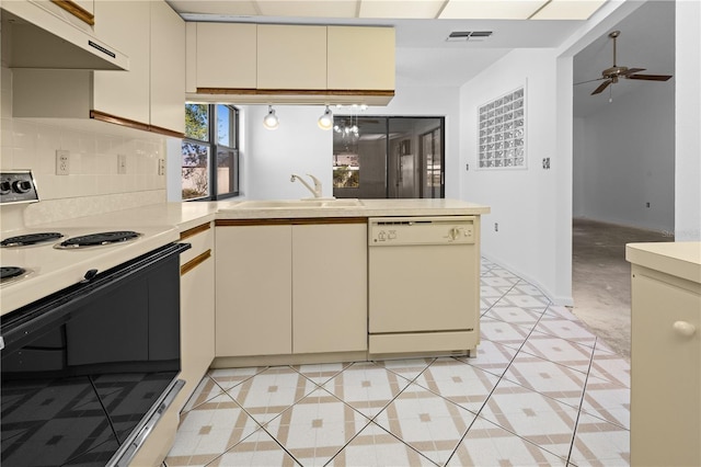 kitchen featuring white appliances, ceiling fan, cream cabinets, light carpet, and kitchen peninsula