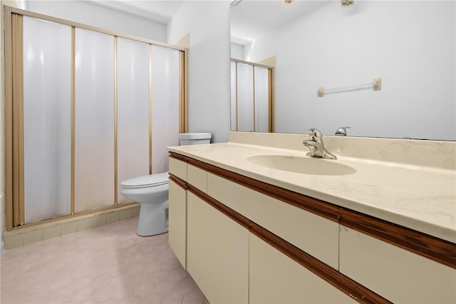 bathroom featuring tile patterned flooring, vanity, a shower with door, and toilet