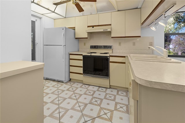 kitchen featuring sink, white appliances, and cream cabinetry