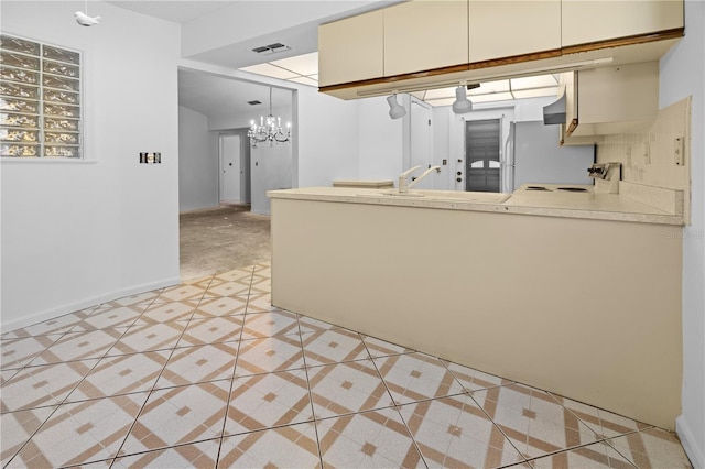 kitchen featuring light tile patterned floors, white fridge, pendant lighting, cream cabinetry, and stove