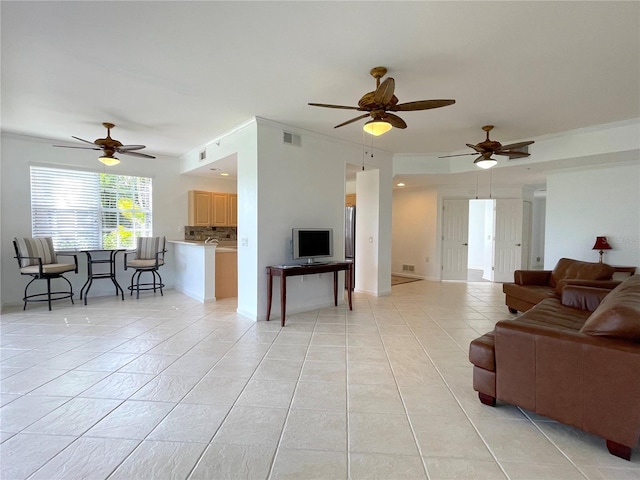 living room featuring crown molding, ceiling fan, and light tile patterned floors