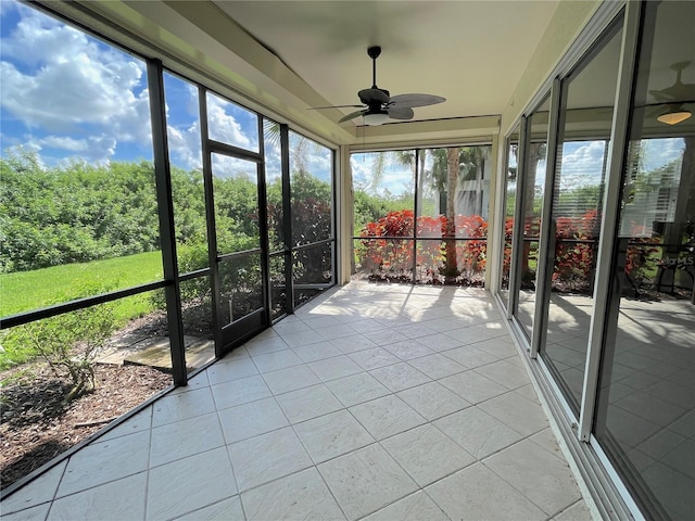 unfurnished sunroom with ceiling fan