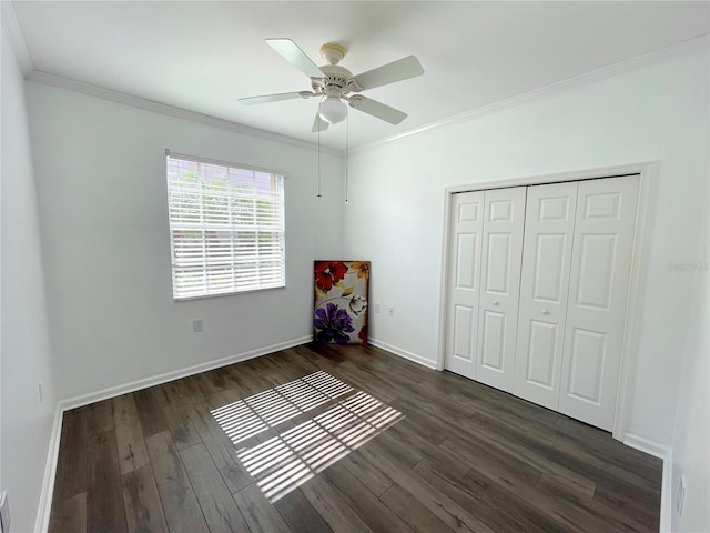 unfurnished bedroom with dark hardwood / wood-style flooring, ornamental molding, a closet, and ceiling fan