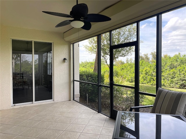 unfurnished sunroom featuring ceiling fan