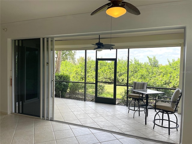 unfurnished sunroom with ceiling fan