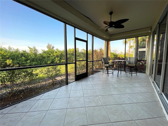 unfurnished sunroom featuring ceiling fan