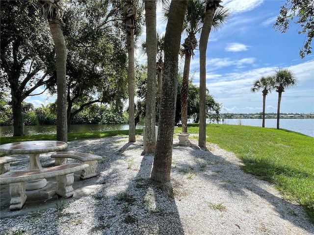 view of home's community with a lawn and a water view