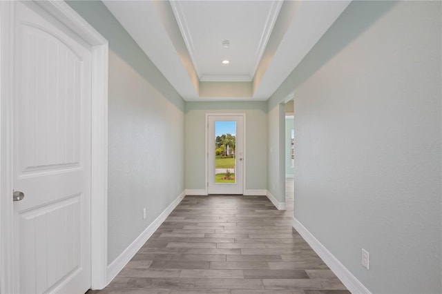 doorway to outside featuring ornamental molding, dark hardwood / wood-style flooring, and a tray ceiling