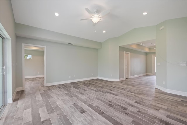 unfurnished room featuring light hardwood / wood-style flooring, ceiling fan, and a tray ceiling