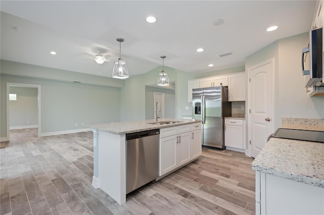 kitchen with appliances with stainless steel finishes, ceiling fan, white cabinets, sink, and hanging light fixtures