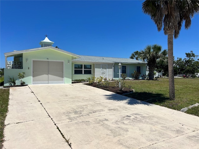 ranch-style home with a garage and a front lawn