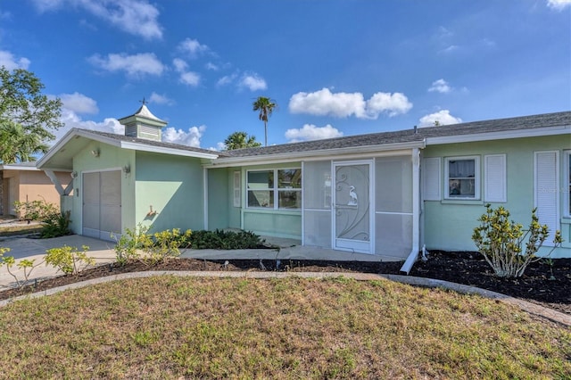 ranch-style home with a garage and a front yard