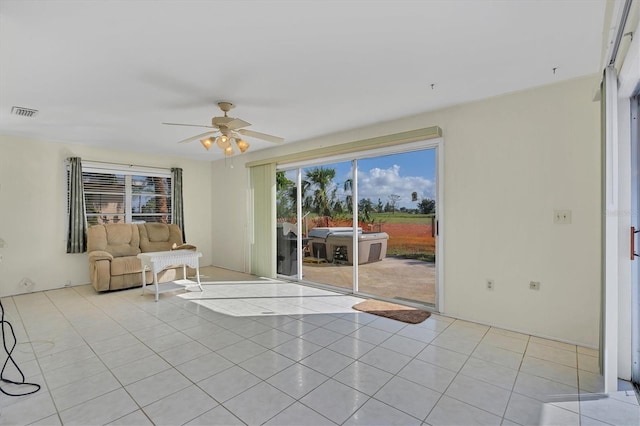 unfurnished living room with ceiling fan and light tile floors