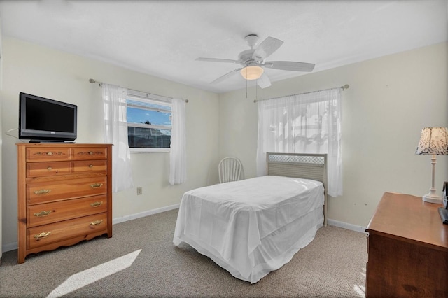 carpeted bedroom featuring multiple windows and ceiling fan