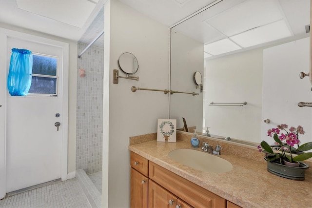 bathroom featuring tile floors, oversized vanity, and a tile shower