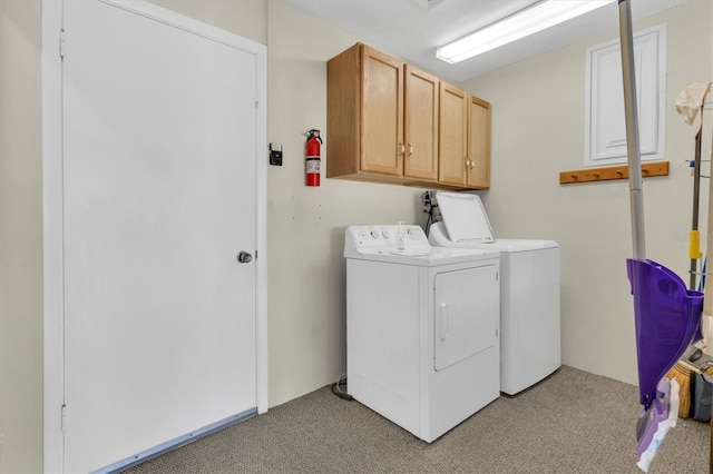 laundry area featuring light carpet, washing machine and dryer, and cabinets