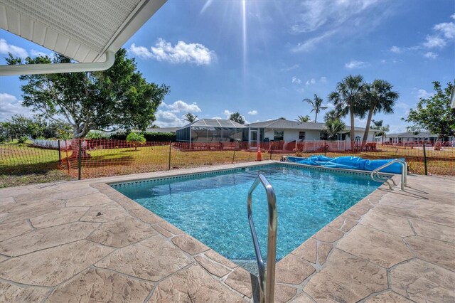 view of swimming pool featuring a patio and a yard