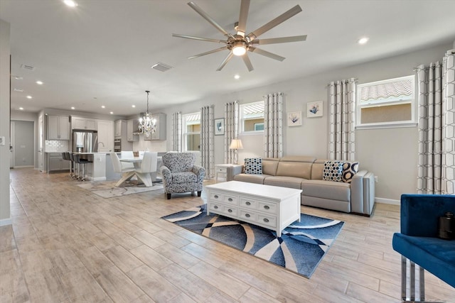 living room featuring ceiling fan with notable chandelier