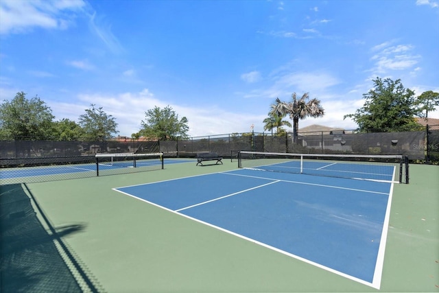 view of tennis court featuring basketball hoop