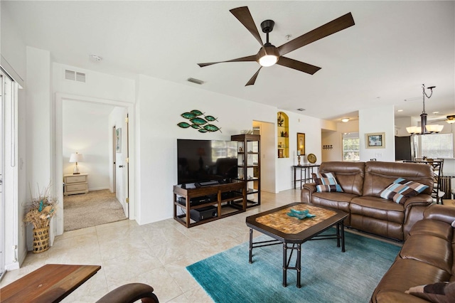 living room with light colored carpet and ceiling fan with notable chandelier